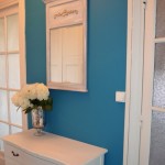Матовая синяя прихожая с белой дверью и мебелью
