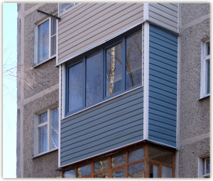 Аккуратная обшивка сайдингом балкона в синем цвете