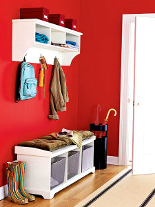 Соврменная прихожая в матовой красной поверхностью стен и белой мебелью